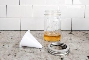 Mason jar with apple cider vinegar, metal band and Culinesco fruit fly funnel on kitchen counter
